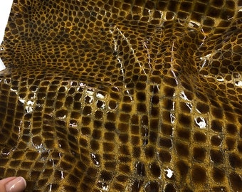 May include: A piece of brown crocodile embossed leather with a glossy finish.