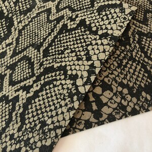 May include: Black and beige faux snakeskin fabric with a textured pattern.