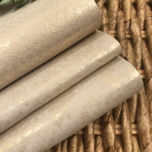 May include: A stack of three beige fabric sheets with a subtle shimmer. The fabric has a woven texture and a subtle sheen.