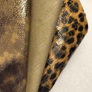 May include: Three different fabric swatches, one with a gold glitter finish, one with a brown and black animal print, and one with a brown and white striped pattern.