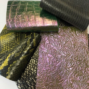 May include: Five different pieces of leather in various colors and patterns. The leather is green, black, yellow, and brown. The leather has a variety of textures, including smooth, embossed, and textured.