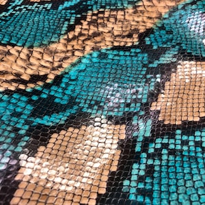May include: Close-up of a blue and brown snakeskin pattern. The pattern is made up of small, overlapping scales.