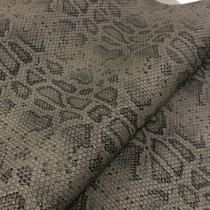 May include: Gray faux leather fabric with a snakeskin pattern and a subtle embossed floral design.