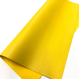 May include: A piece of yellow leather with a textured surface.