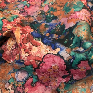 May include: Abstract floral fabric with a watercolor-like design in shades of pink, blue, green, and brown.