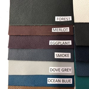 May include: A swatch card showing 10 different colors of leather. The colors are: Forest, Merlot, Eggplant, Smoke, Dove Grey, Ocean Blue, Natural, White, Teal, and Black.