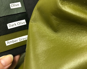 May include: Close-up of a piece of green leather with a textured surface. The leather is shown next to a color chart with the labels "Espresso Brown", "Olive", "Dark Olive", and "Amber Green".