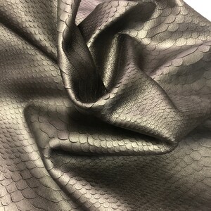 May include: Black faux leather fabric with a textured snake skin pattern.