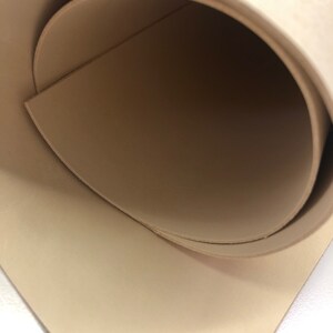 May include: A close-up of a beige leather sheet rolled up, showing the inside of the roll.