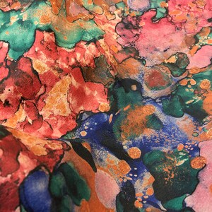 May include: Abstract fabric with a colorful, swirling pattern in shades of pink, blue, green, and orange. The fabric has a textured, almost metallic look.
