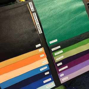 May include: A color chart of leather swatches in various colors, including black, tan, coral, peach, turquoise, navy, royal blue, baby blue, kelly green, forest green, apple green, jade green, purple, purple passion, lilac, and lavender. The chart is labeled "Superb Leather M 7001".
