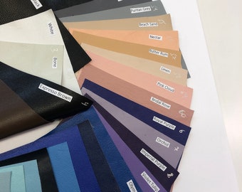 May include: A color chart of leather swatches in various shades of brown, beige, pink, blue, and purple. Each swatch is labeled with a name, such as "Bombay Brown", "Prairie Sand", "Moon Mist", "Orchid", and "Deep Ocean".