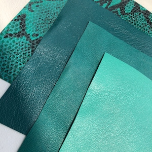 May include: Four pieces of leather in different shades of green. The top piece has a snakeskin pattern. The other three pieces are smooth.