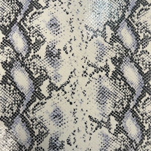 May include: White faux leather with a black and light blue snakeskin pattern.