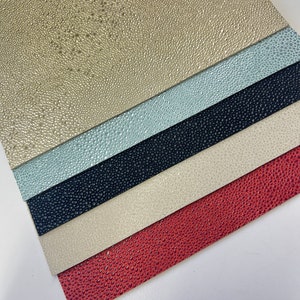 May include: Five sheets of textured faux leather in different colors: beige, light blue, black, cream, and red.