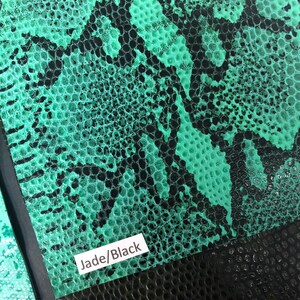 May include: Close-up of a green and black snakeskin-textured fabric swatch. The swatch has a label that reads "Jade/Black".