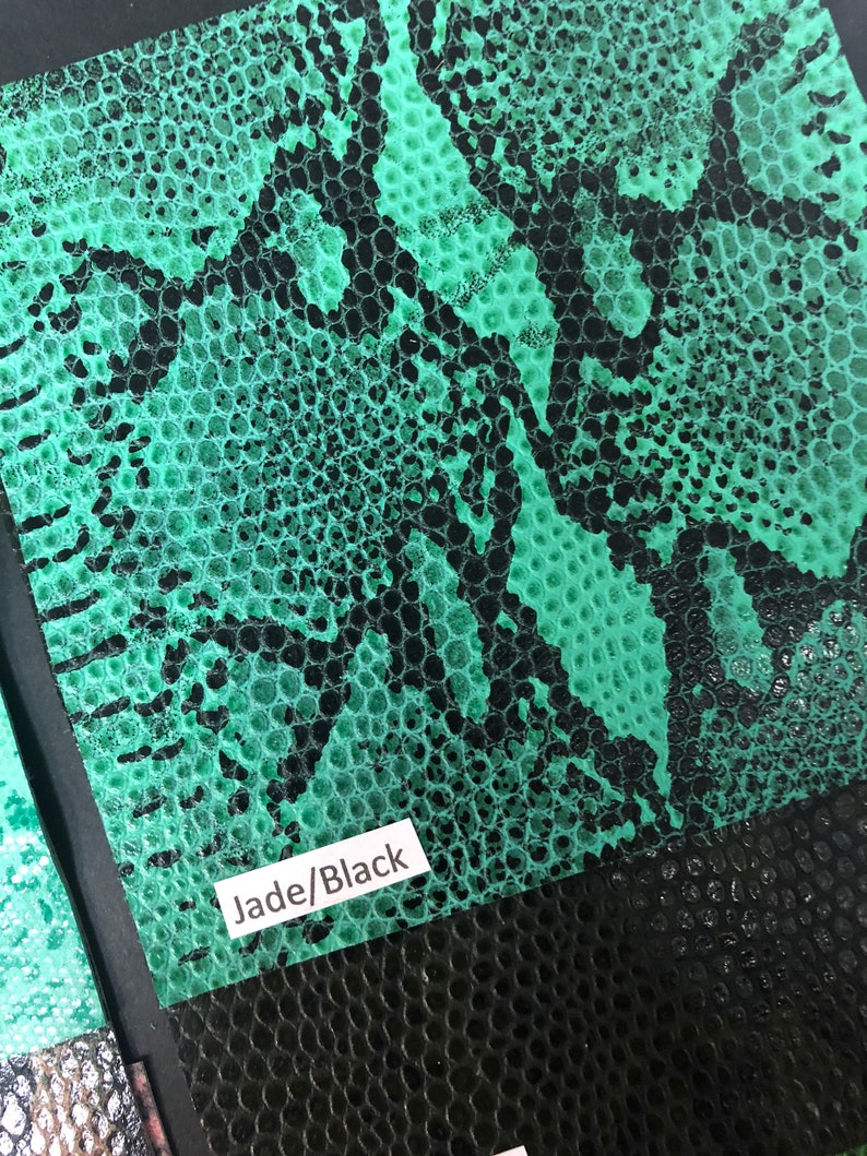 May include: Close-up of a green and black snakeskin-textured fabric swatch. The swatch has a label that reads "Jade/Black".