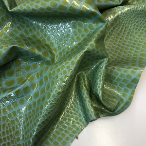 May include: Green faux leather fabric with a crocodile skin pattern.