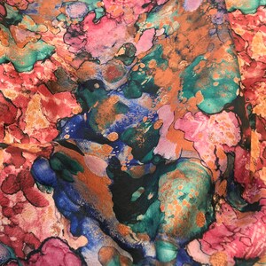 May include: Abstract fabric with a colorful, marbled pattern in shades of pink, blue, green, and gold. The fabric has a soft, flowing texture.