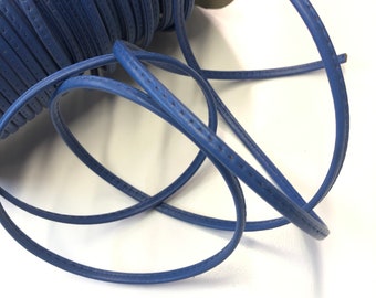 May include: A spool of blue leather cord with a stitched edge. The cord is coiled and ready to be used for crafting projects.