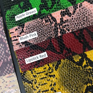 May include: Close-up of five different colored faux snakeskin fabric swatches. The swatches are labeled "Dark Olive", "Apple Green", "Blush Pink", "Lipstick Red", and "Sunset Yellow".