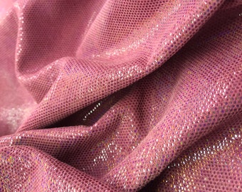 May include: Close-up of a pink iridescent fabric with a textured, dotted pattern. The fabric is soft and shimmery, with a subtle sheen.