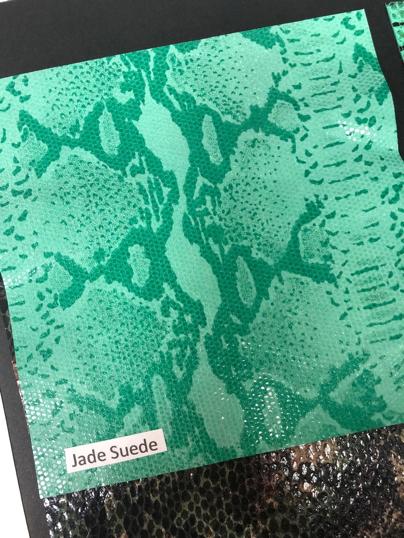 May include: A close-up of a jade green snakeskin fabric swatch with the text "Jade Suede" printed on a white label.