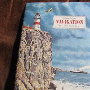 May include: A vintage book cover for "Navigation" from the Science Service Science Program. The illustration shows a lighthouse on a cliff, a ship on the sea, and a small aeroplane in the sky. The colour scheme includes blues, whites, and reds.