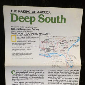 May include: A vintage National Geographic Magazine cover from August 1983, titled "Deep South." The cover features a map of the southern United States with text and illustrations. The magazine is open, revealing articles about the region's history.