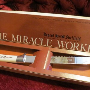 May include: A vintage knife set in its original box. The box is brown with gold lettering that reads "The Miracle Worker." The knife has a cream-colored handle and a serrated blade. The box also includes the text "The Sharpest Knife You'll Ever Use."