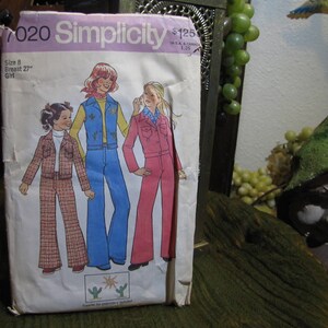 Può includere: Modello di cucito Simplicity vintage per abbigliamento da ragazza, con illustrazioni di tre ragazze in abiti degli anni '70. Il modello include un completo giacca e pantaloni, un gilet e jeans a zampa, e una tuta. La confezione è contrassegnata con la taglia, la misura del seno e il logo Simplicity.