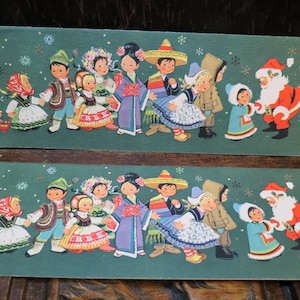May include: Two vintage Christmas cards with a teal background. The cards feature illustrations of children in traditional clothing from different cultures, Santa Claus, and snowflakes. The cards are rectangular and have a festive theme.