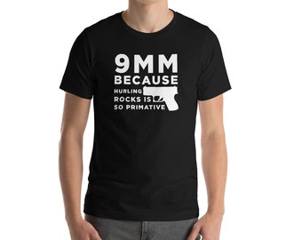 May include: Black t-shirt with white text that reads "9MM because hurling rocks is so primitive" and a silhouette of a handgun.