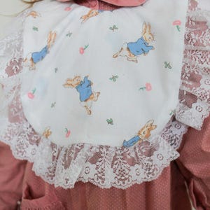 Babero de encaje elegante de Peter Rabbit con lazos para niños y bebés