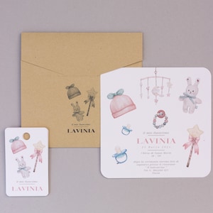 Invito per Battesimo e tag in carta martellata con delicati disegni di giochi e vestiti per bambina. Stampa digitale in alta risoluzione