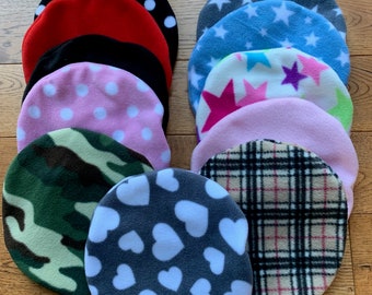 May include: A collection of ten circular fleece fabric pieces featuring various patterns including black with white polka dots, solid red, solid black, pink with white polka dots, green camouflage, grey with white hearts, grey stars, blue stars, multi-coloured stars, and plaid.