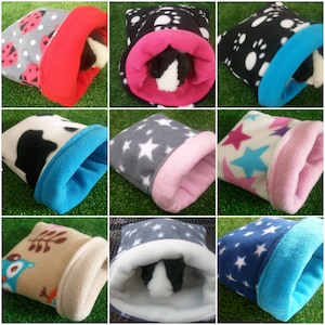 May include: Nine different fleece pet beds for small animals. The beds are in various colours and patterns, including stars, ladybirds, and paw prints. Some of the beds have a pink lining, while others have a blue lining.