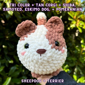 May include: A handmade, plush dog toy in white, brown, and tan. The toy has large, black eyes, a brown nose, and pink cheeks. The text on the image reads "TRI COLOR + TAN CORGI + SHIBA, SAMOYED, ESKIMO DOG, + POMERANIAN" and "SHEEPDOG + TERRIER".