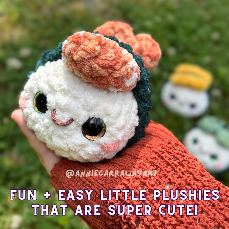 May include: A plush sushi roll with a white, green, and orange design, featuring large, expressive eyes and a stitched smile. The text "FUN + EASY LITTLE PLUSHIES THAT ARE SUPER CUTE!" is displayed below the sushi roll.