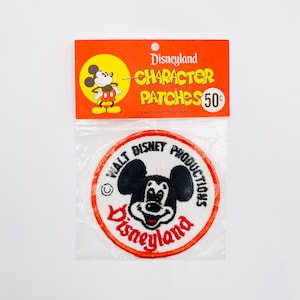 May include: Vintage Disneyland Character Patches in original packaging. The top orange header features Mickey Mouse and the text "Disneyland Character Patches 50¢". The round patch features Mickey Mouse with the text "Disneyland" and "Walt Disney Productions".