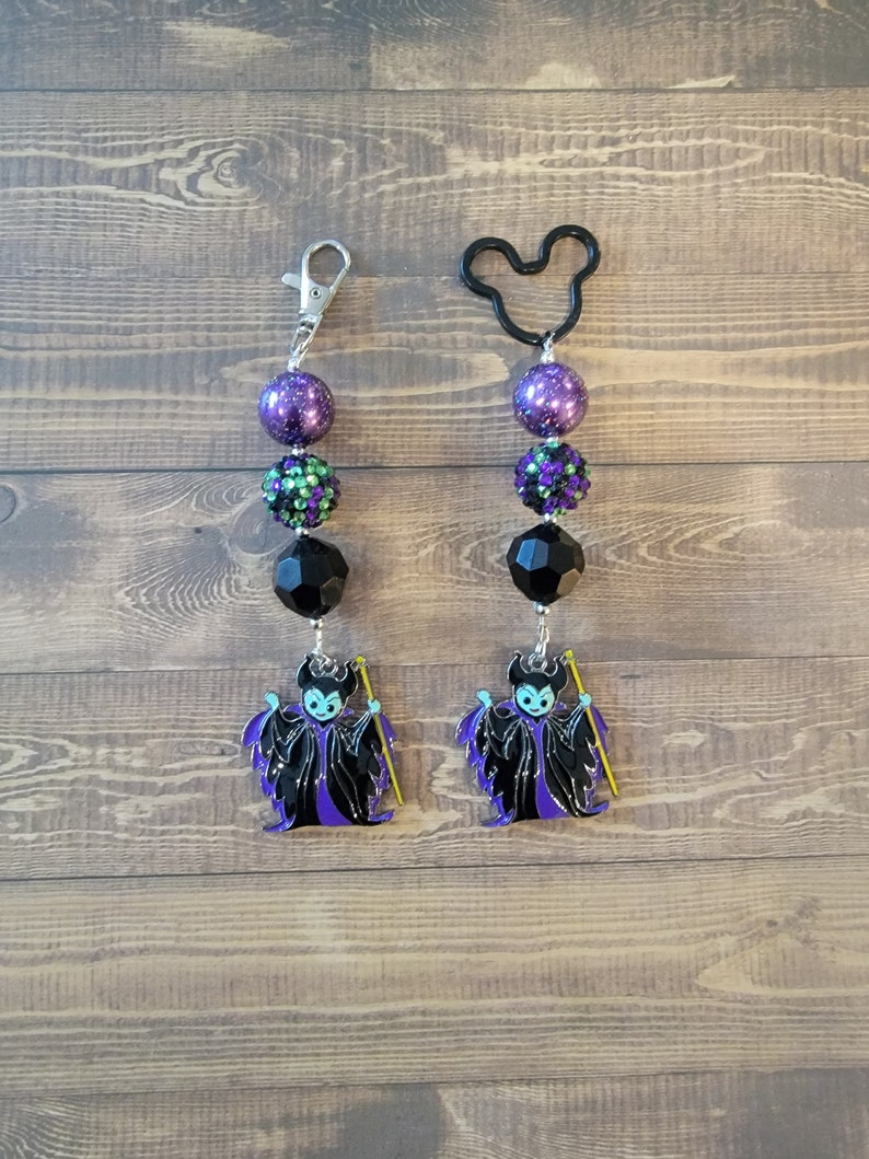 Maleficent Keychain, Purse Charm, Backpack Charm. Mistress of all Evil. Sleeping Beauty Villain. Made with 20mm beads in purple, black and multi colored rhinestone. Comes with a lobster claw or black Mickey head shaped Key ring. Maleficent Pendant.
