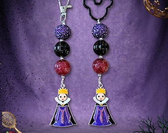 May include: Two beaded keychains featuring a character charm wearing a gold crown and purple cape. Each keychain includes a purple glitter bead, a black bead, and a red glitter bead. One keychain has a silver lobster clasp, the other a black Mickey-shaped ring.