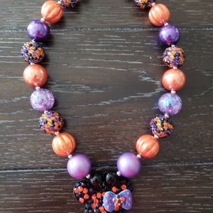 May include: A purple, orange, and black Halloween-themed beaded necklace with a black and orange rhinestone Minnie Mouse head charm.