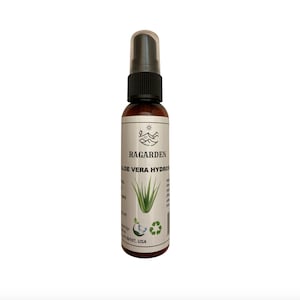 May include: A brown bottle with a black spray nozzle and a white label. The label says "RAGARDEN ALOE VERA HYDRATING SPRAY". The bottle is sitting on a white background.