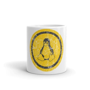 May include: White ceramic mug with a yellow circle and a black penguin logo. The circle has a distressed, vintage look.