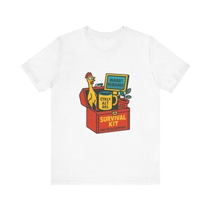 May include: A white t-shirt featuring a graphic of a red toolbox labeled SURVIVAL KIT FOR TECH SUPPORT. Inside are a yellow rubber chicken, a yellow mug labeled CTRL+ALT+DEL, a computer monitor reading REBOOT REQUIRED, and a potted plant.