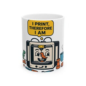 Könnte beinhalten: Ein weißer Keramikbecher mit einem Cartoon-3D-Drucker mit lächelndem Gesicht, der einen kleinen orangefarbenen Dinosaurier druckt. Über dem Drucker befindet sich eine gelbe Sprechblase mit dem schwarzen Text, I PRINT, THEREFORE I AM. Um den Drucker herum sind kleine Symbole wie ein grüner Dinosaurier, eine blaue Tasse, ein Schraubenschlüssel und eine Schachfigur.