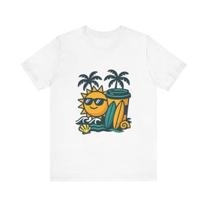 Peut inclure: Un t-shirt blanc avec une illustration graphique d'un soleil jaune souriant portant des lunettes de soleil noires, deux palmiers, une tasse de café, deux planches de surf, des vagues et un coquillage en jaune, bleu sarcelle et bleu foncé.