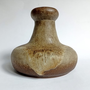 Może przedstawiać: Brązowy i beżowy ceramiczny wazon z szeroką podstawą i wąską szyjką. Wazon ma marmurkową glazurę o rustykalnym wyglądzie.