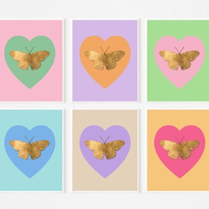 Puede incluir: Seis impresiones de arte imprimibles con una mariposa dorada dentro de una forma de corazón. Cada impresión tiene un color de fondo diferente: rosa, lavanda, verde, azul, beige y naranja.